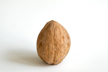 Close up delicious organic unopened walnut with nutshell from top view isolated on a white background.