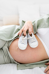 close-up belly of a pregnant woman with blue socks Pregnancy, motherhood, preparation and waiting...