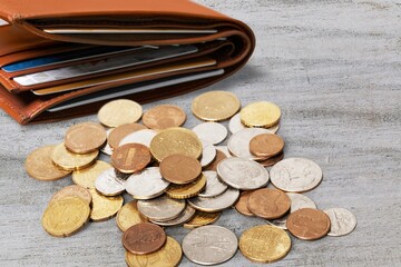 Set of different golden coins with wallet on the desk.