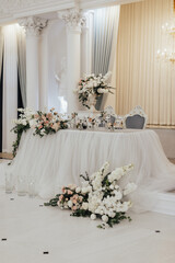 Classic wedding reception in restaurant. Table decoration with candles and flowers.	