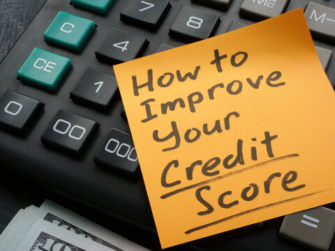 Memo stick with How to improve your credit score inscription on the calculator.