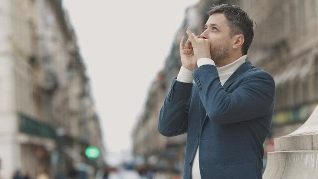 Man with stubble playing harmonica on the street