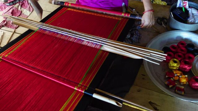 A hilly Chakma tribal woman weaves cloth with a hand-made loom in her own home in the Rangamati district.