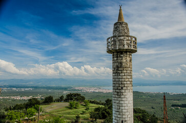 Obraz premium The only surviving structure among the destroyed houses of an abandoned village in Turkey. The minaret of a mosque.