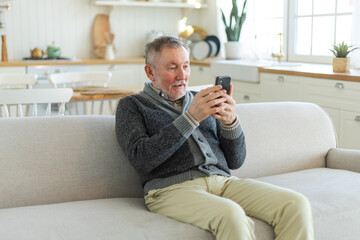 Happy middle aged senior man talk on video call with friends family. Laughing mature old senior grandfather having fun speaking with grown up children online. Older generation modern tech usage