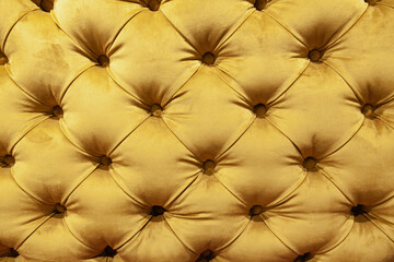 Soft yellow fabric sofa with sewn-in buttons.