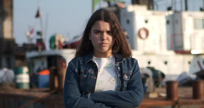 A young girl looking angrily at the camera on the beach. The girl's expression of anger is a powerful depiction of her intense emotions, making it a special moment