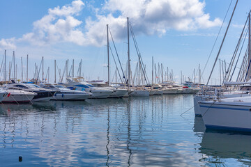 Fototapeta na wymiar Panorama. Sea port. Yachts, boats, boats in sea bay. A clear sunny day with white clouds on horizon.