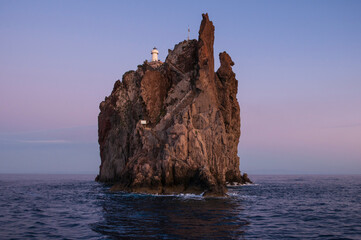 Small island of Strombolicchio at sunset / The island of Strombolicchio in the sunset is a lava rock in front of Stromboli, Italy. - 604982685