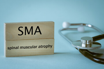 SMA Rare disease abbreviation Spinal Muscular Atrophy written on wooden blocks along with medical...