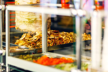 The cooked meat for shawarma lies on a baking sheet next to other ingredients