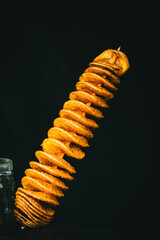 Crispy salty fried Tornado Potato chips on a stick, street food, finger food. Copy space.