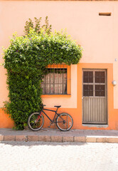Fototapeta na wymiar Bicicleta estacionada en fachada de casa naranja