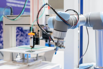Pick and place robotic arm manipulator during work at modern robot exhibition, trade show, factory, plant - close up view. Industrial, manufacturing, engineering and automated technology concept