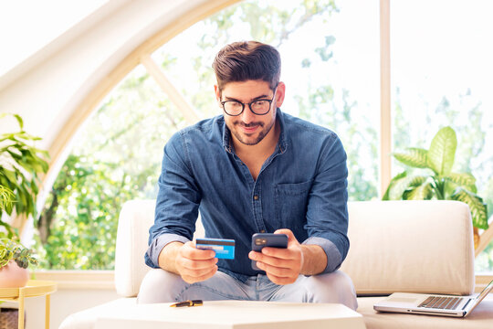 Confident man sitting at home and shopping online