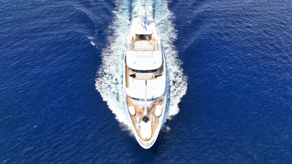 Aerial drone photo of luxury yacht with wooden deck cruising open ocean deep blue Aegean sea