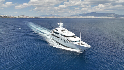 Aerial drone photo of luxury yacht with wooden deck cruising open ocean deep blue Aegean sea