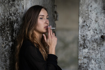 Fototapeta premium Portrait of a smoking girl on a blurred background