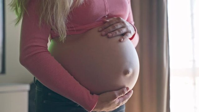 Woman playing with her beautiful pregnant belly, mom touching and stroking her tummy showing her love and affection for her baby child, prenatal period of pretty woman, pregnant belly concept