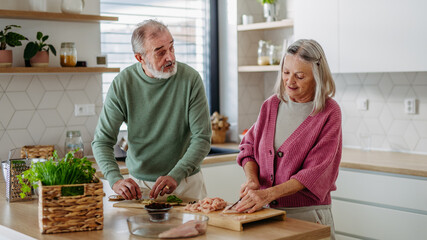 Senior couple cooking together in their kitchen.