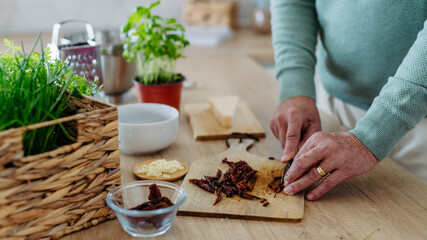 Close up of senior man cutting dried tomatoes.