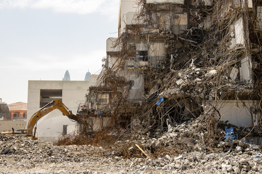 excavator equipped with a hydraulic hammer demolishes an old building 