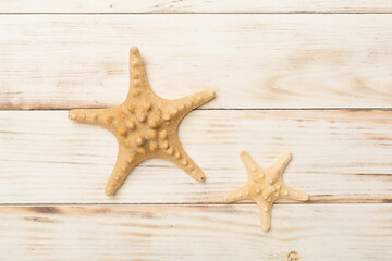 Fototapeta na wymiar Starfishes on wooden background, top view