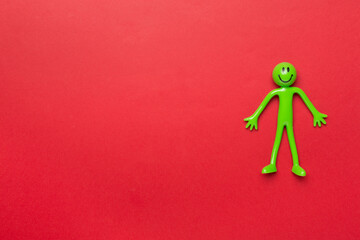 Human figure toy on color background, top view