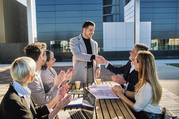 exciting moment captures a team of six individuals engaged in a work meeting, where one member,...