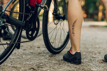 Fototapeta na wymiar Unrecognizable woman cyclist having a bicycle chain mark on the leg