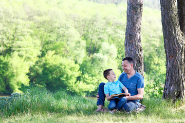 father and son reading bible book