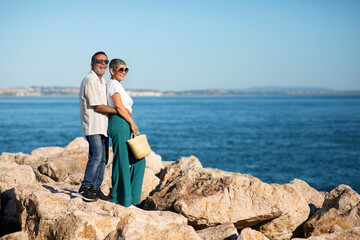 Fototapeta na wymiar Happy European Senior Couple Hugging Near Ocean Posing Outside