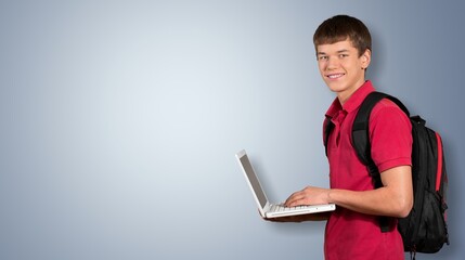 Young happy teenager student  holding laptop