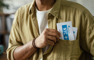 Close up of man with plane tickets in his pocket, travel agency concept. - obrazy, fototapety, plakaty