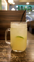 A glass of fresh lime ice with a lime slices served at the table.