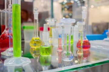 Medical glass bottles and vials in showcase at pharmaceutical exhibition, pharmacy laboratory - close up. Pharma industry, science, medicine, experiment and healthcare concept