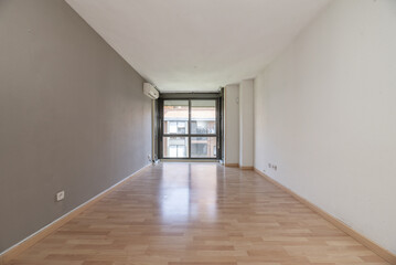 A living room with a window, a gray wall
