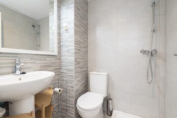 A small bathroom with a shower without a curtain