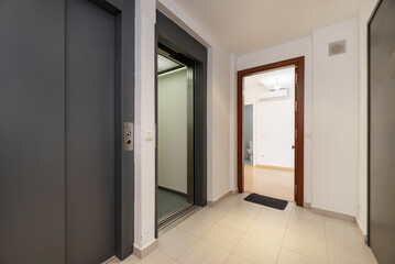 Double elevators on a landing of a residential apartment building with stoneware floors