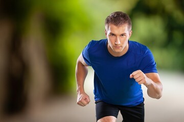 Happy young man running in city park