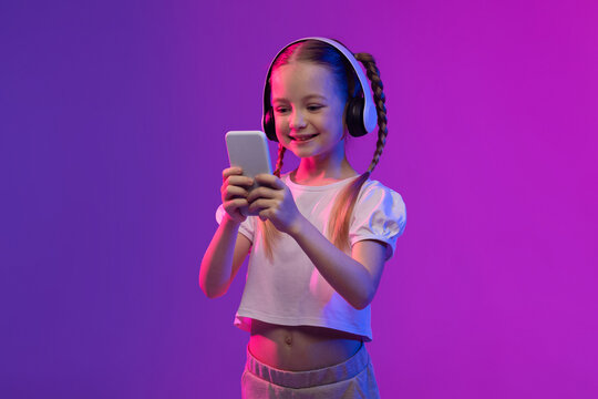 Social media influencer kid using smartphone and wireless headset