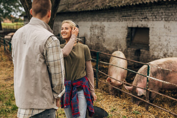 A woman and a man work at the animal farm.
