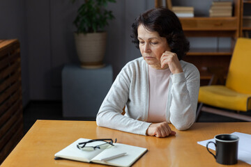 Sad tired ill sick lonely disappointed older senior woman sitting at home alone. Unhappy mature grandmother experiencing grief relative death bad news. Stressed elder lady suffering from loneliness