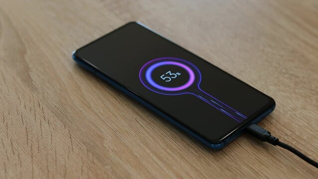 Mobile smartphones charging on a wooden table