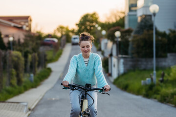 Young woman on electro bicycle, concept of commuting and ecologic traveling.