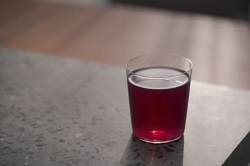 purple drink in tumbler glass on concrete countertop with copy space