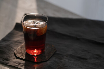 Cola with ice in tumbler glass on wood table with copy space