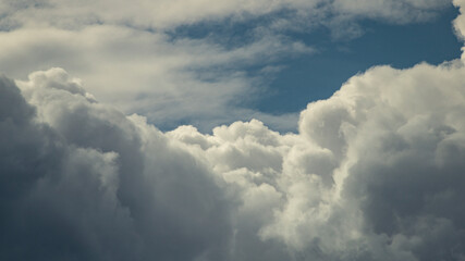 Rain clouds close-up. Rain clouds in sunlight. Big clouds in the sky. Fluffy clouds in sunlight