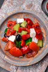 Delicious fresh juicy greek salad with feta cheese, olives, peppers and tomatoes