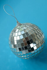 Shiny disco ball against blue background. fashion symbol in a nightclub. Minimalistic holiday composition.